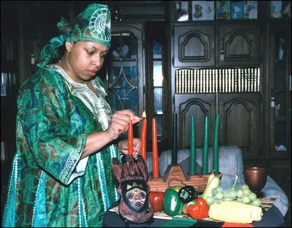 woman lighting candle for kwanzaa