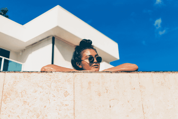 woman in the un looking over a wall, summer skin care