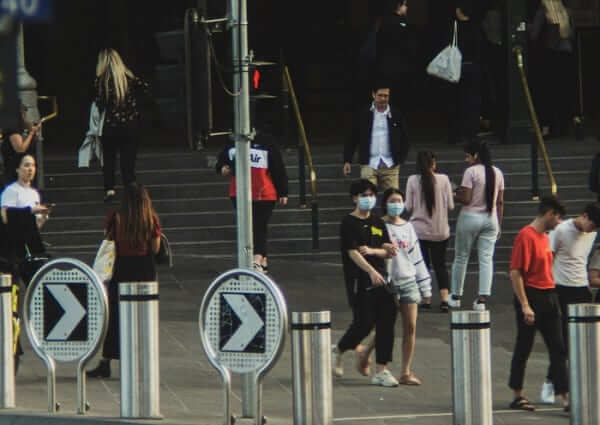 People walking outside a Melbourne train station. 