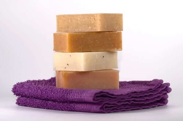 a pile of soaps on a purple towel