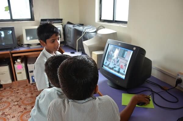 Gyanankur students operating an old model of a computer