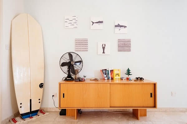 a surfboard and fan inside a room