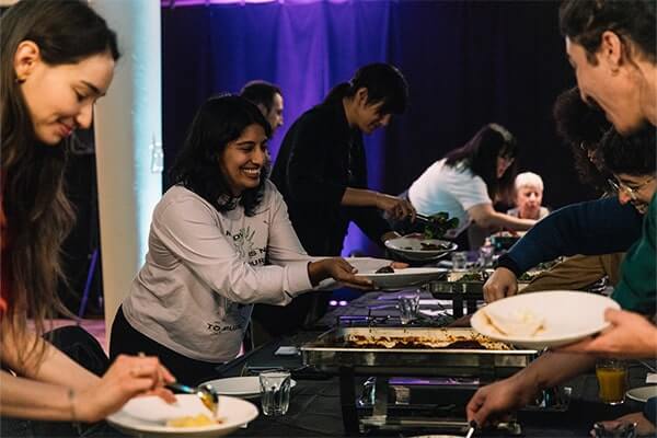 Audiences enjoy a communal meal as part of Okkoota's public program