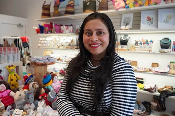 Poonam Jeet Sokhi stands in the middle of Sisterworks' Richmond store. Products are seen out of focus in the background.
