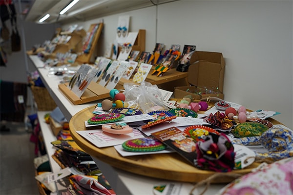 Some earrings and brooches that are handmade are on display.