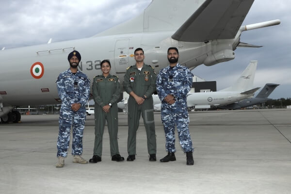 four defence personel stand in front of an Indian aircraft.