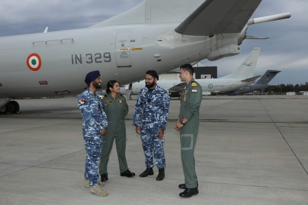 four defence personel stand in front of an indian aircraft