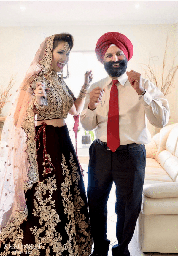 an indian bride and her father dance together