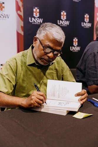 Perimal signing copies of his book Pyre at UNSW Sydney