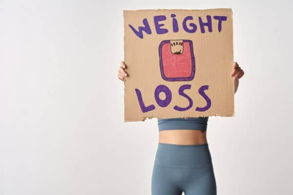 Person holding up a sign which states weight loss