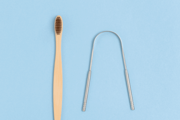 Photo of a tongue scraper and brush- cleaning your tongue