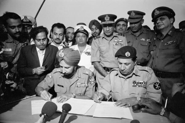 General. Jagjit Singh Aurora (left), Chief of Staff of the Indian Army, and General Amir Abdullah Khan Niazi of the Pakistani Army sign the papers that would end the 1971 war between the two countries.